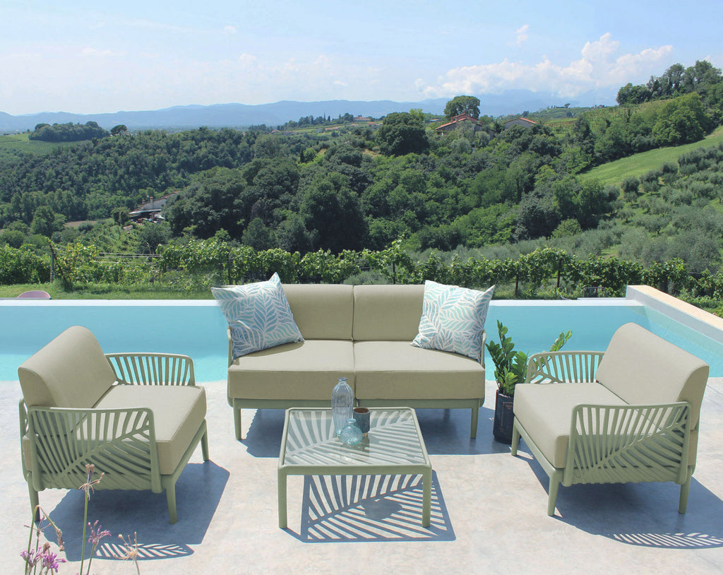 Set completo da salotto Guaranà con tavolino, divano e poltrone verde oliva a bordo piscina con vista panoramica.