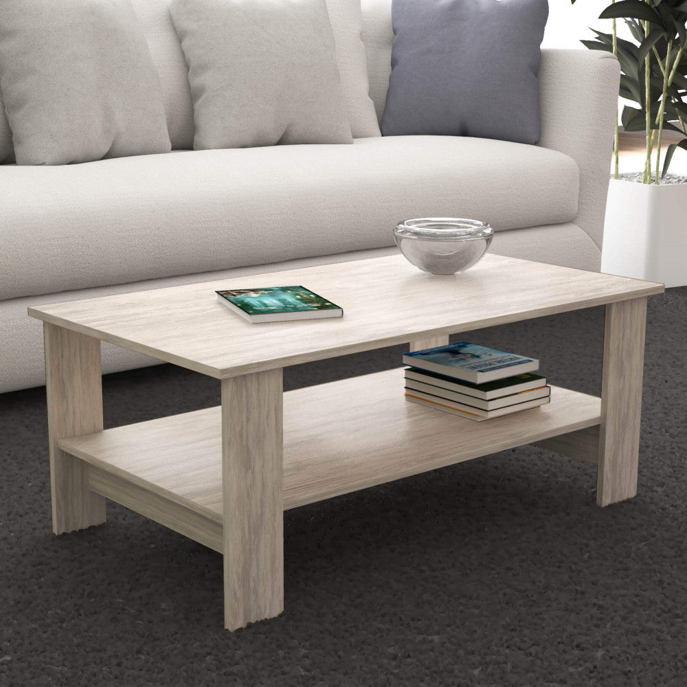 Tavolino da salotto inserito in un living contemporaneo con tappeto scuro e divano chiaro, decorato con una ciotola in vetro.