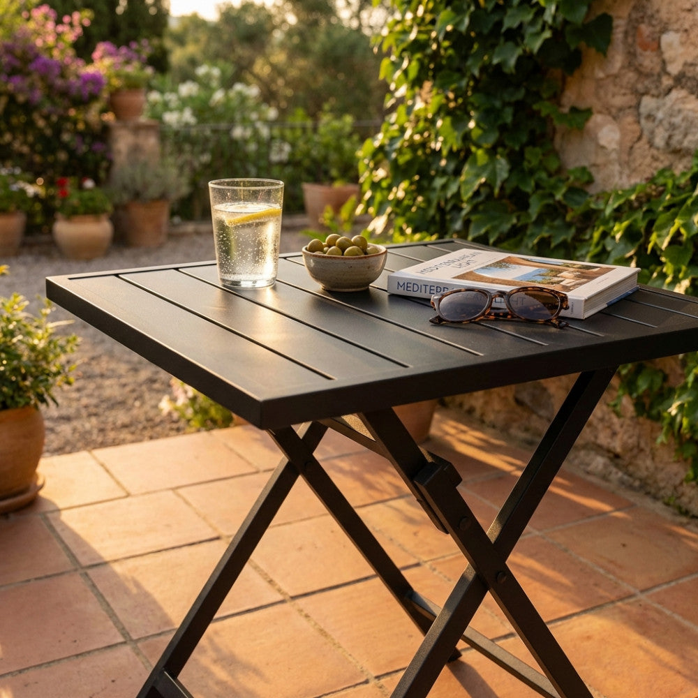 Dettaglio del piano a doghe del tavolo Alabama, illuminato dalla calda luce del tramonto con accessori lifestyle.