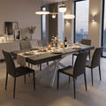 Tavolo da pranzo allungabile Darren ambientato in una sala moderna serale con sedute scure.