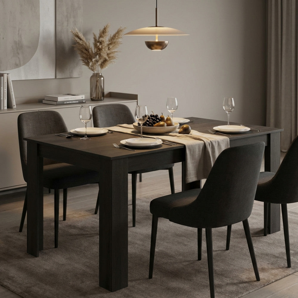 Tavolo da pranzo allungabile Emmet in melaminico antracite ambientato in una sala da pranzo moderna con sedie scure.