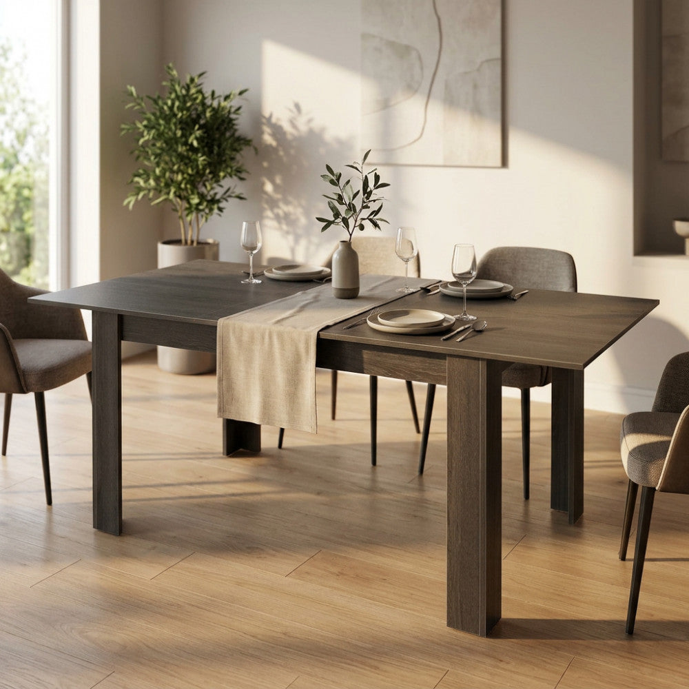 Tavolo da pranzo allungabile Emmet in melaminico taupe, allestito in un luminoso soggiorno moderno con sedie imbottite.