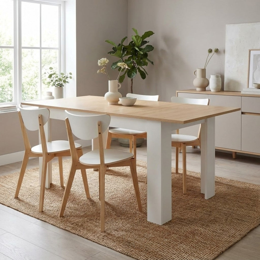 Tavolo Archibald ambientato su un tappeto in iuta rustica con sedie in legno e bianco, illuminato da luce naturale.