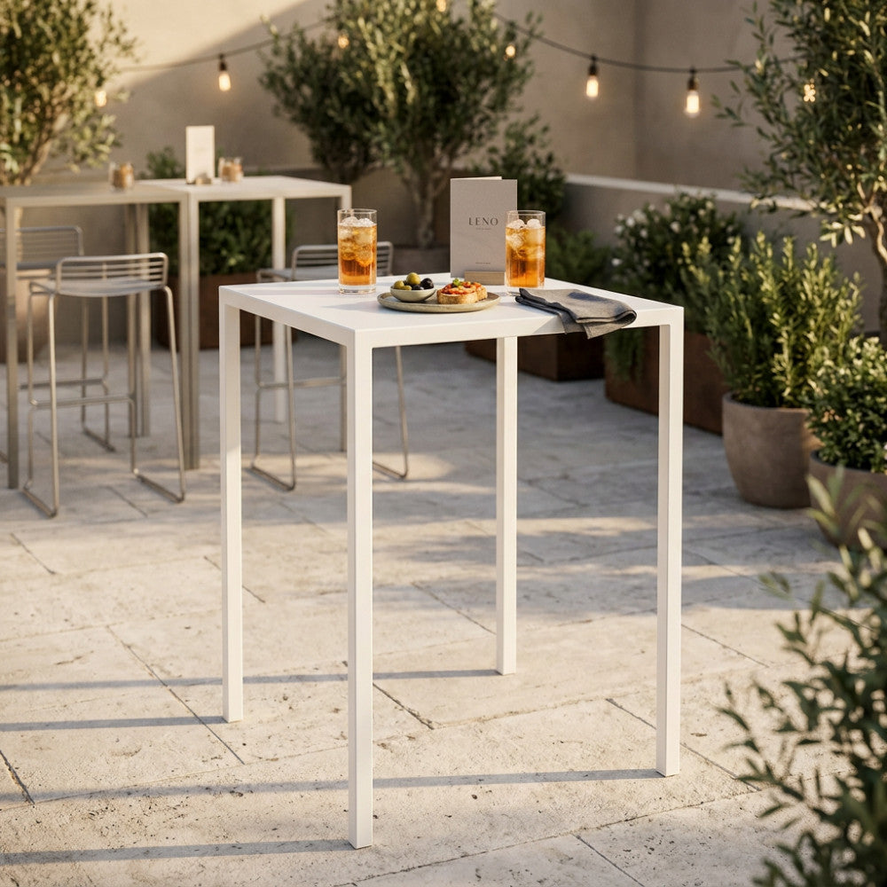 Tavolo da giardino autolivellante in metallo bianco allestito per un aperitivo su un patio soleggiato.
