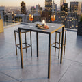 Tavolo alto quadrato in metallo antracite su una terrazza panoramica al tramonto, allestito con drink e stuzzichini, affiancato da due sgabelli minimalisti.