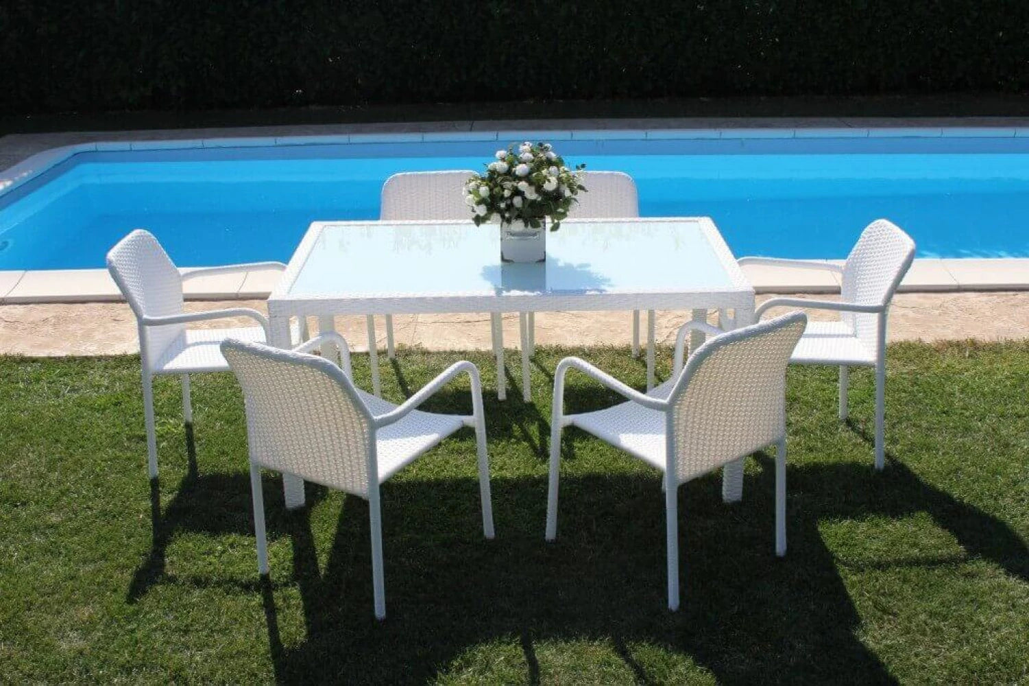 Tavolo da pranzo Azore 150x90 Bianco, struttura in alluminio rivestita in polyrattan e piano in vetro temperato, ambientato bordo piscina