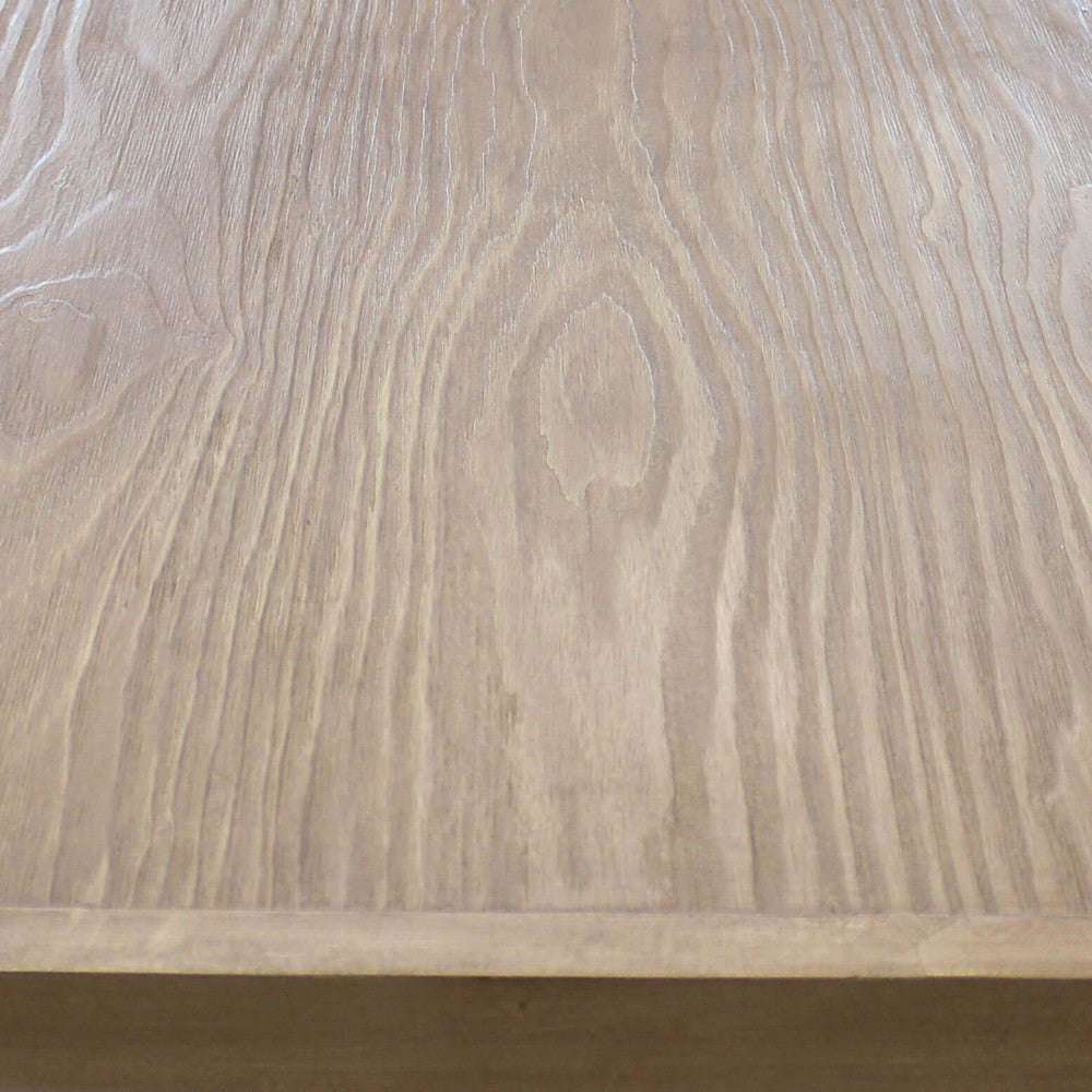 Dettaglio ravvicinato delle venature naturali e della texture tattile del piano in legno del tavolo Boyce.