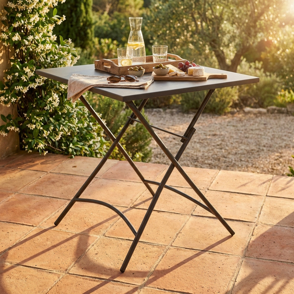 Dettaglio del tavolo pieghevole Bristol 70x70 con aperitivo estivo alla luce del tramonto.