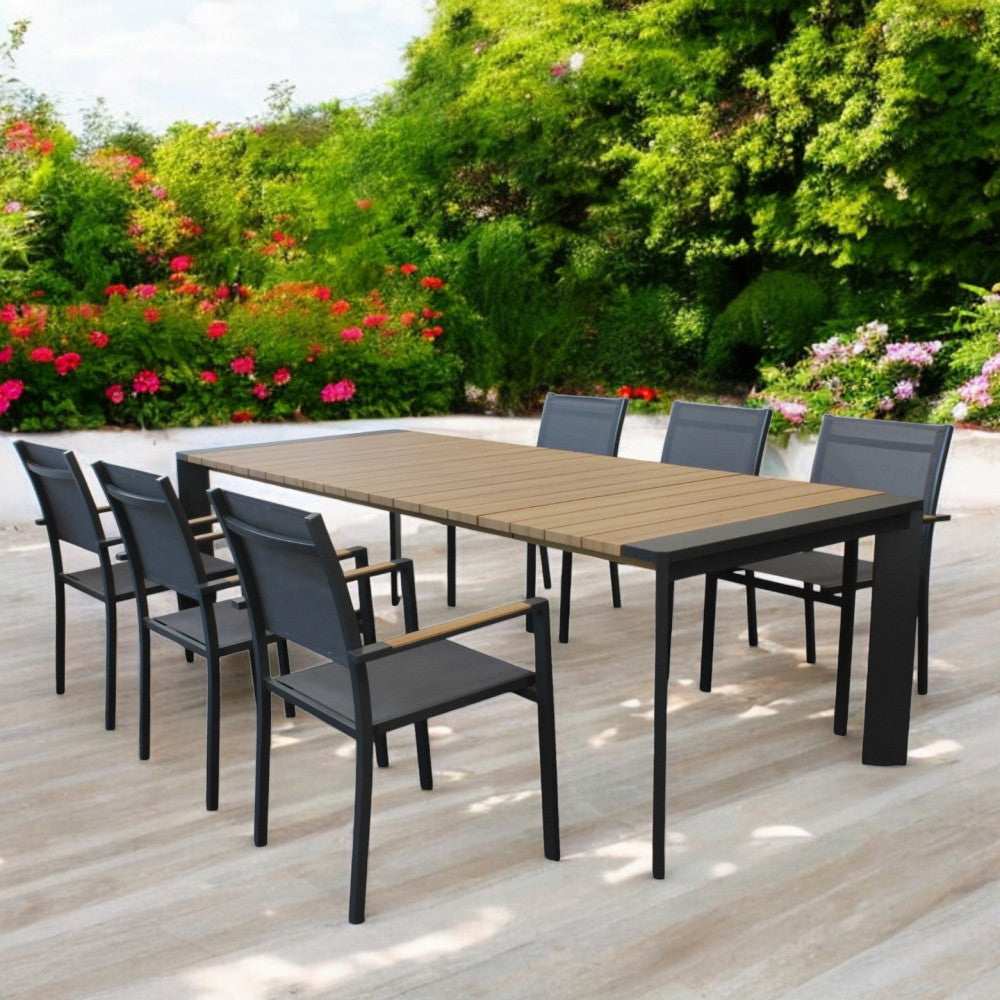 Ambientazione esterna in un giardino rigoglioso con il tavolo Brooklyn e sedie abbinate, perfetto per pranzi conviviali.