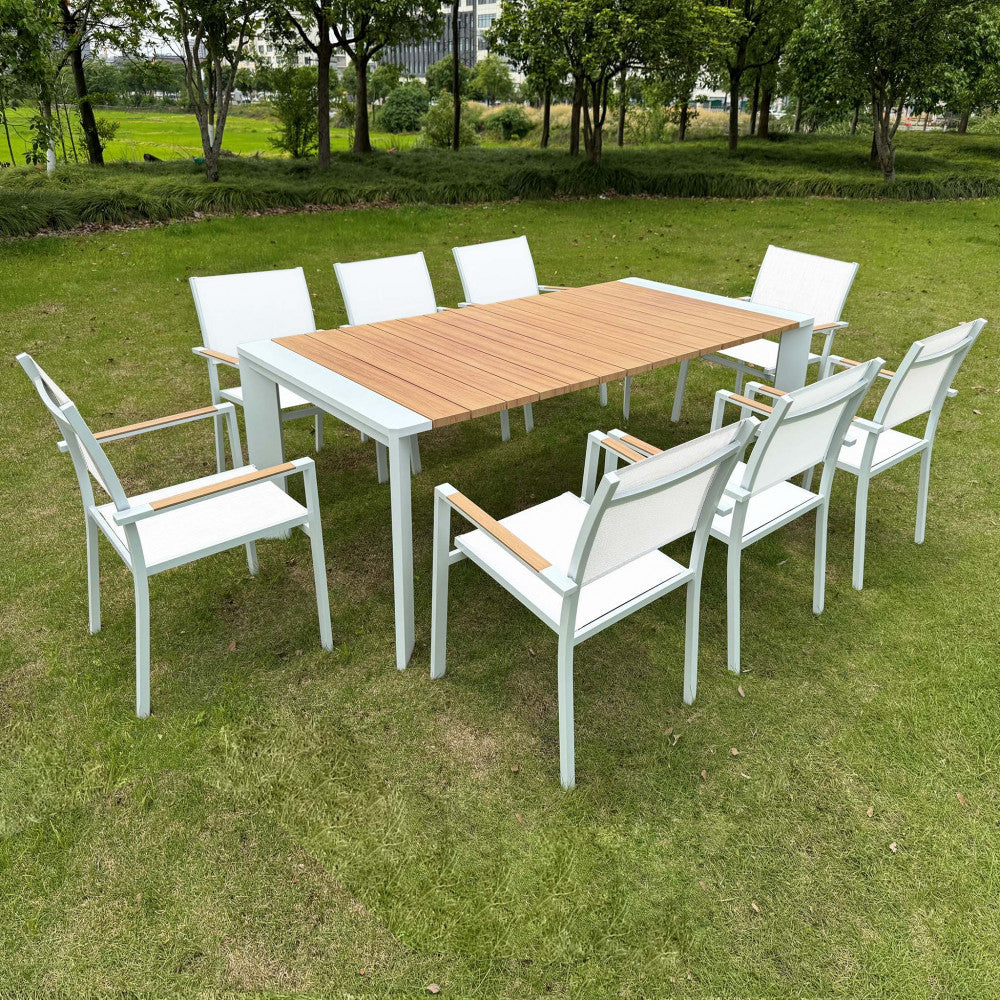 Set completo da pranzo outdoor con tavolo Brooklyn e otto sedie coordinate disposte su un prato verde.