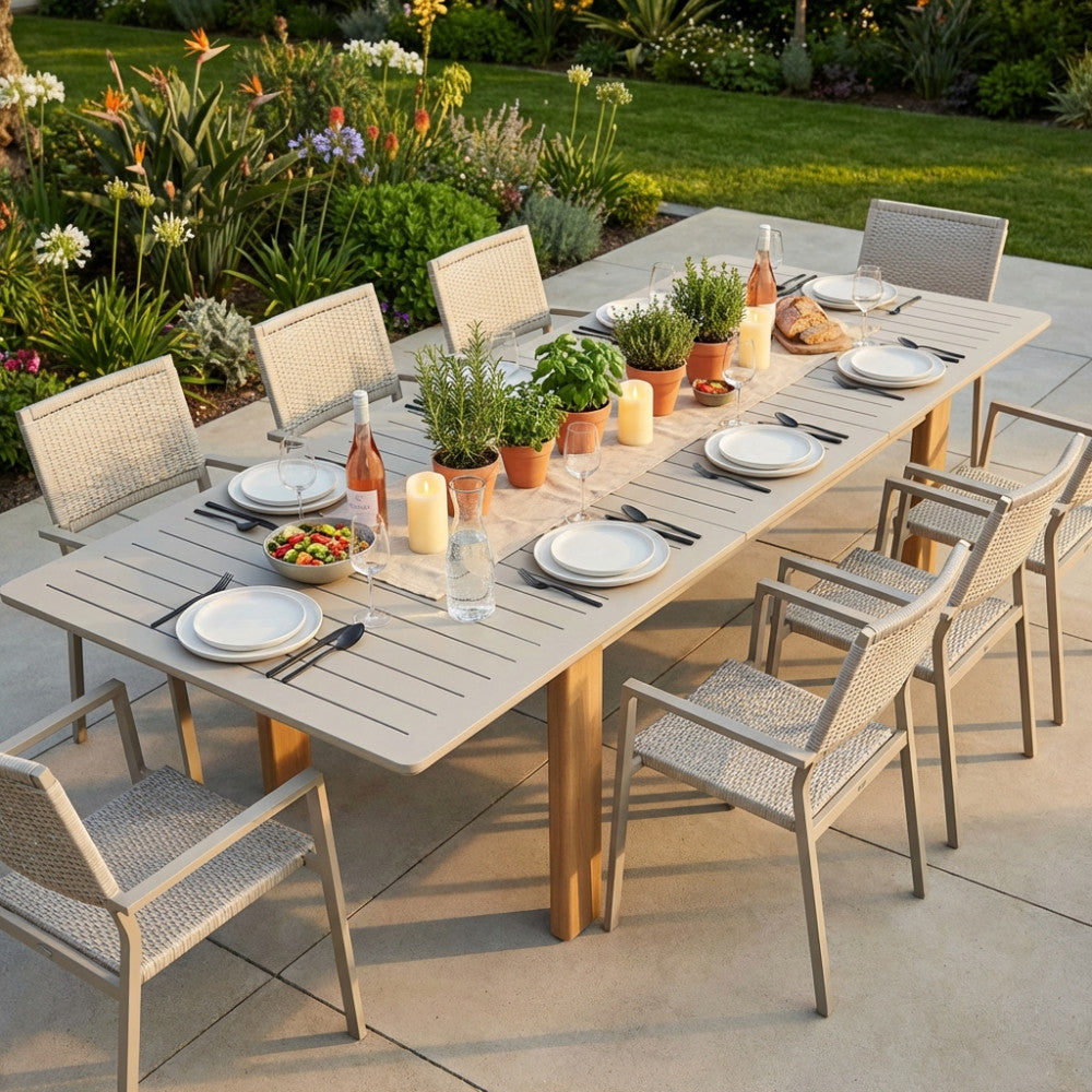 Tavolo da giardino Bullock in alluminio grigio sabbia allestito per un pranzo all'aperto.