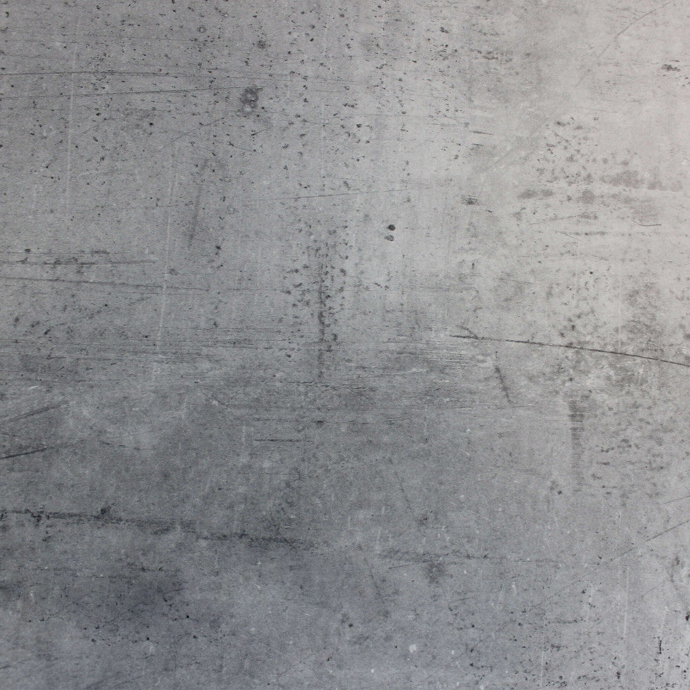 Texture ravvicinata del piano in HPL del tavolo, che mostra una finitura materica grigia simile al cemento spatolato con lievi graffiature decorative.