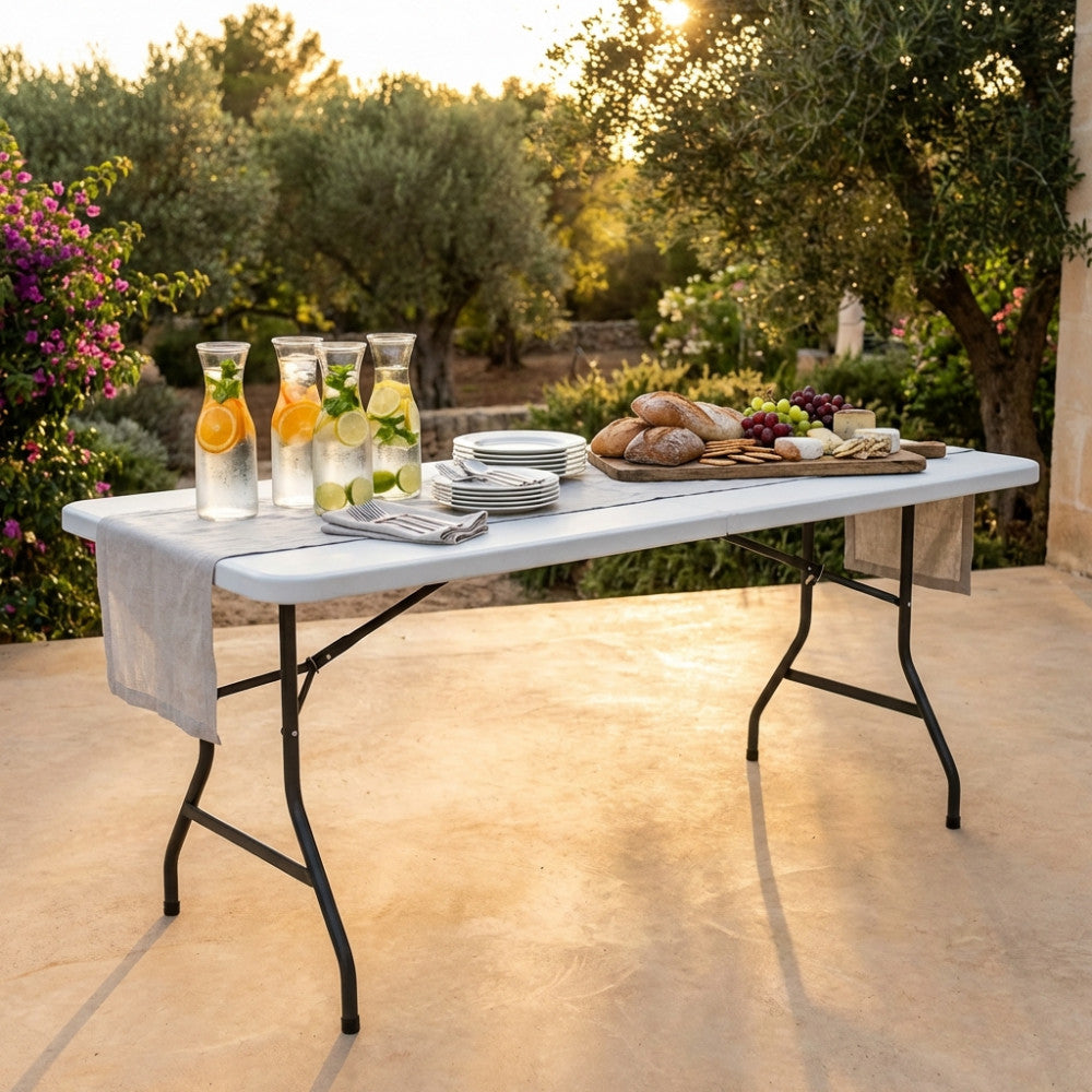 Dettaglio del tavolo da catering CT804530 in acciaio e plastica bianca, imbandito per un rinfresco in giardino.