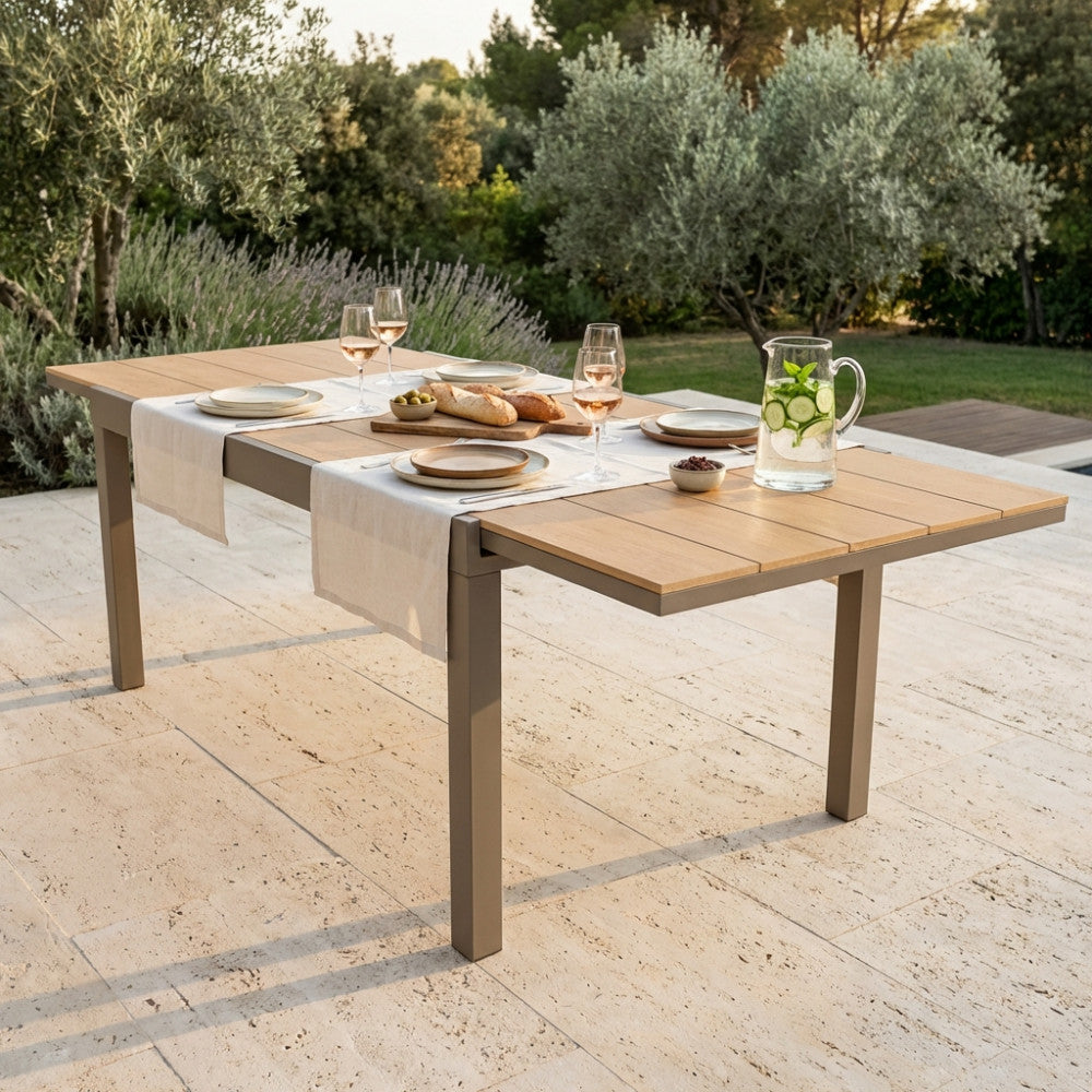 Tavolo da esterno Cayman allestito per un pranzo estivo su una terrazza in pietra.