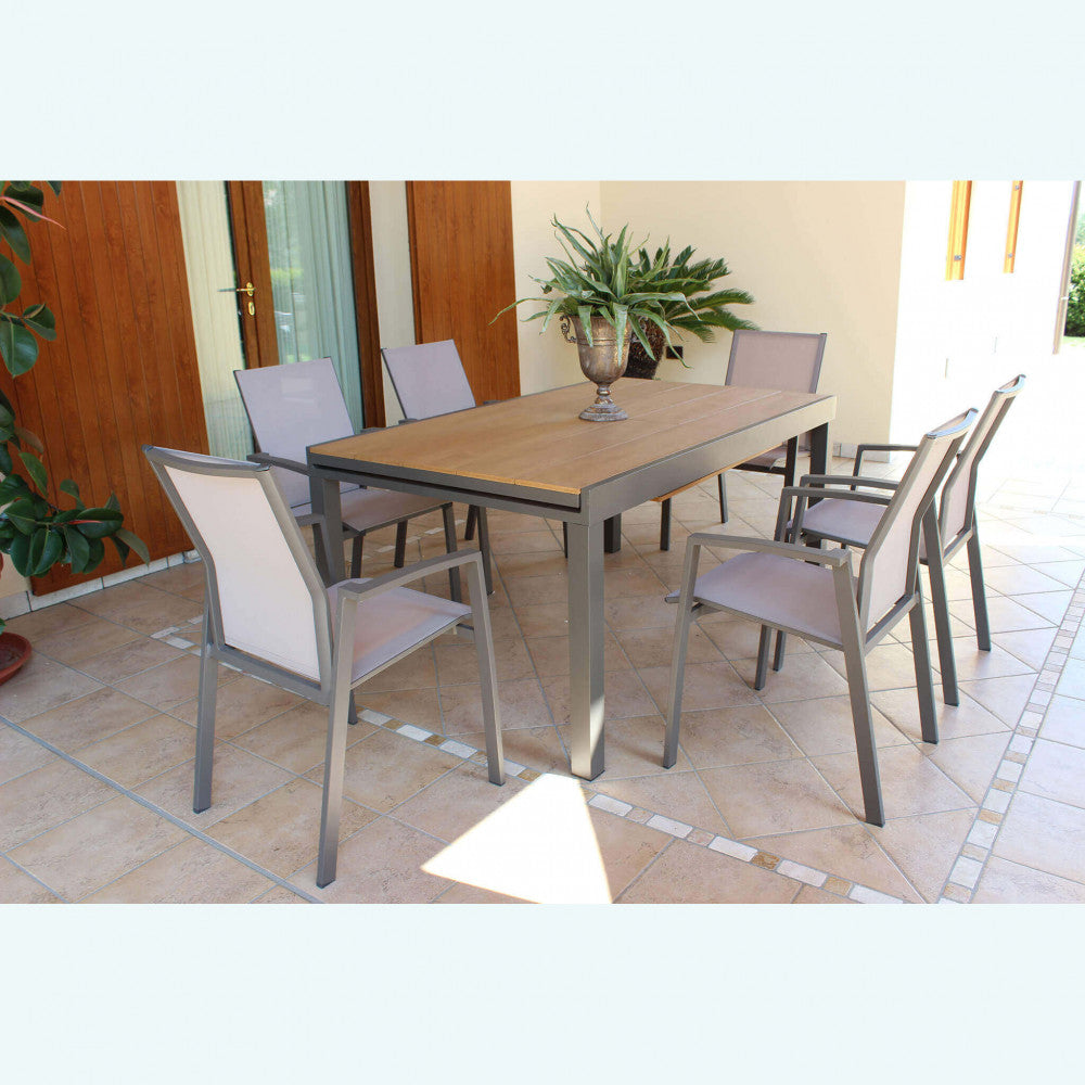 Set da pranzo all'aperto con tavolo Cayman e sedie abbinate su un patio piastrellato.