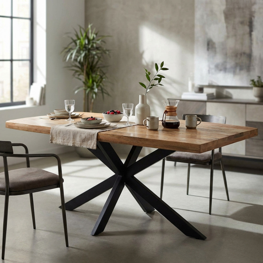 Dettaglio del tavolo da pranzo Corey con base incrociata in metallo nero e piano in legno naturale.