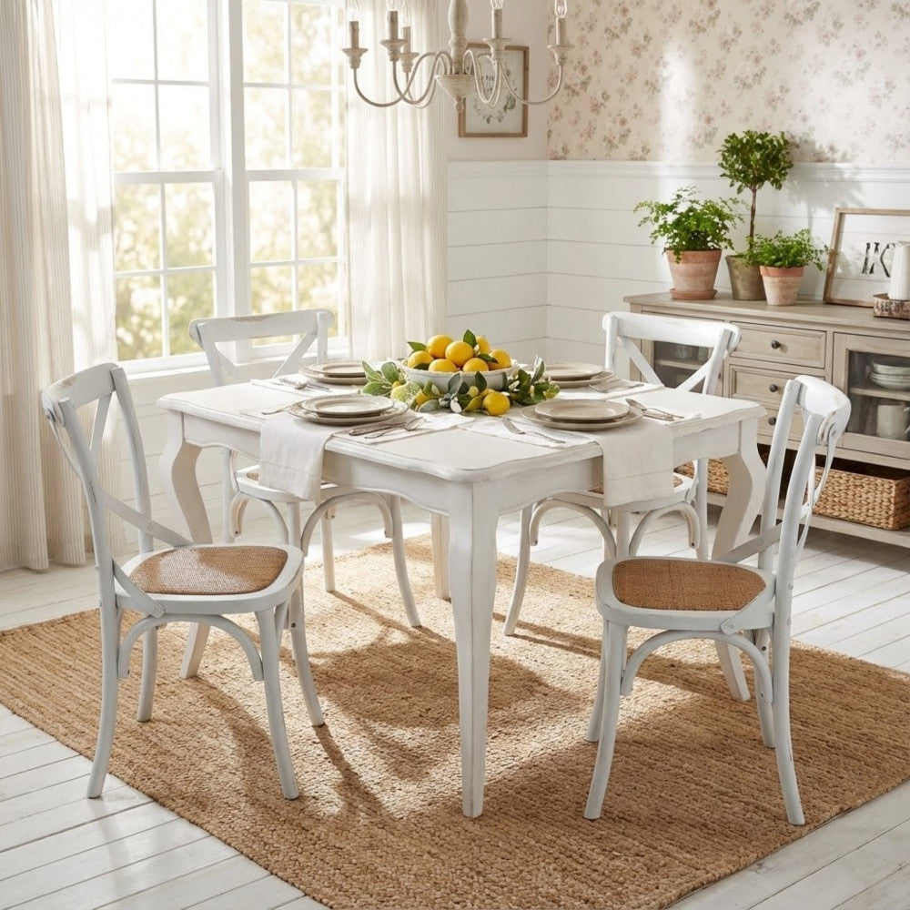 Sala da pranzo completa con tavolo Cross bianco esteso, sedie abbinate e tappeto in juta.