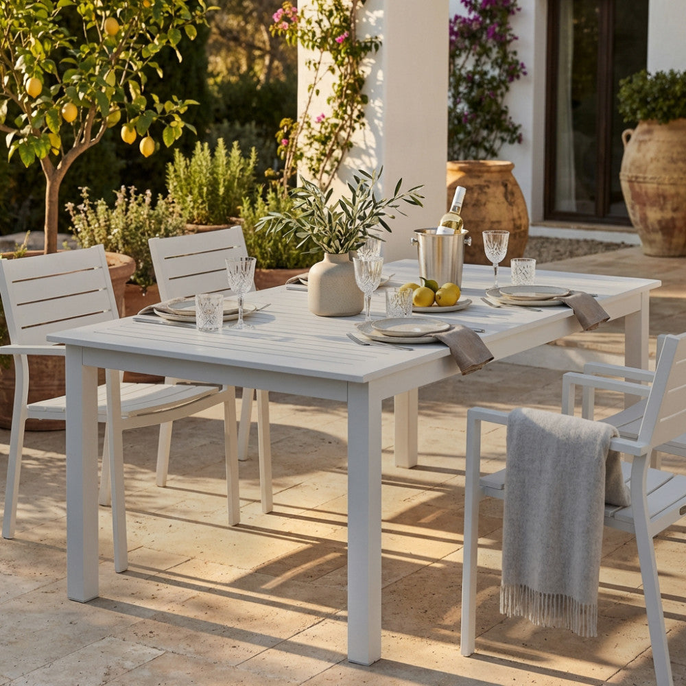Tavolo da giardino Cuba allungabile in alluminio tortora allestito per un pranzo all'aperto sotto un portico.