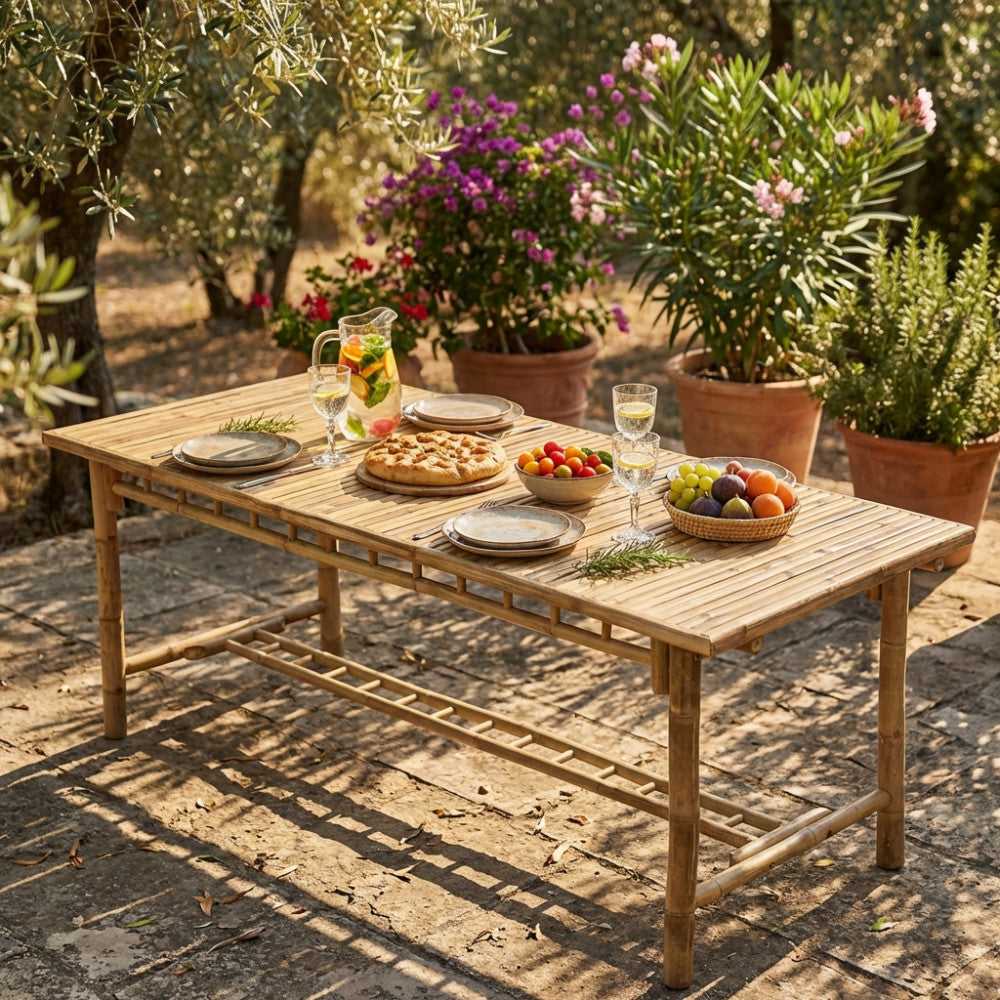 Tavolo da giardino Cuba Libre in legno allestito per un pasto all'aperto con frutta e bevande sotto la luce del sole.