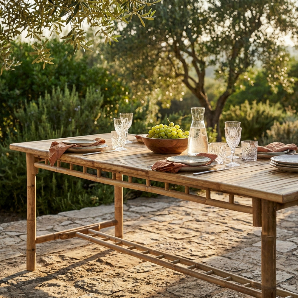 Primo piano del tavolo da giardino in legno Cuba Libre decorato con stoviglie rustiche e uva fresca.