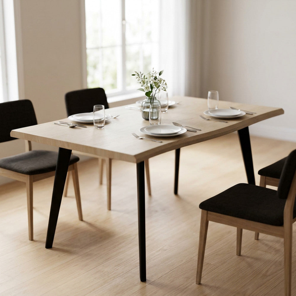 Tavolo da pranzo Dalbert in melaminico bianco effetto legno ambientato in una sala da pranzo luminosa con sedie scure.