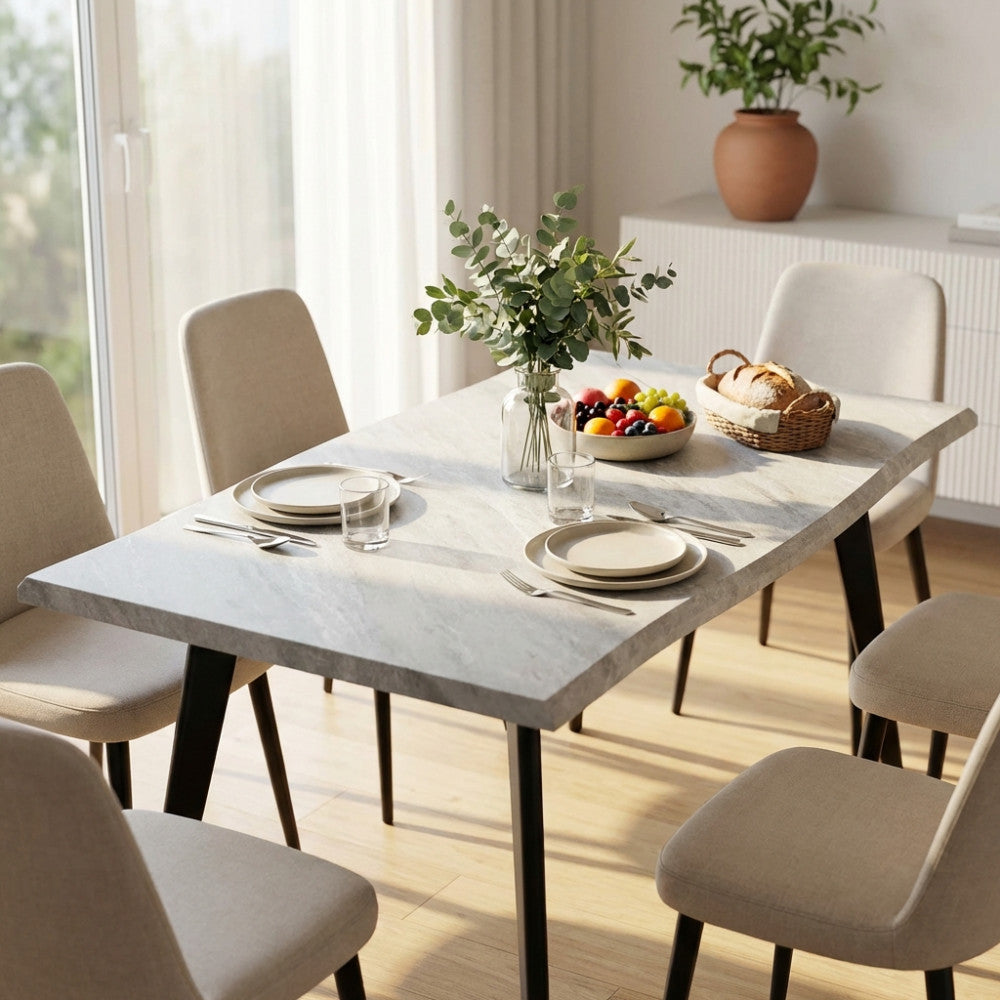 Dettaglio del tavolo da pranzo Dalbert allestito con stoviglie eleganti e un vaso di eucalipto in un ambiente luminoso.