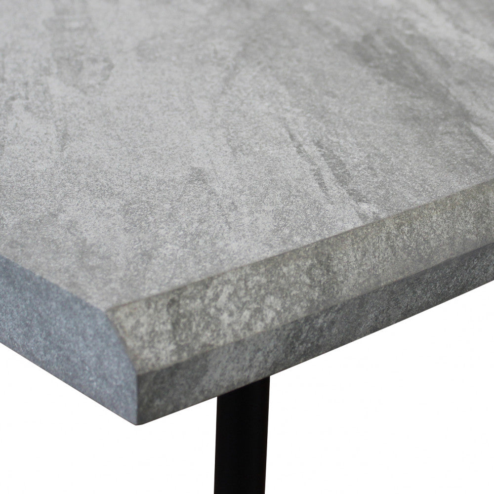 Primo piano del bordo smussato del piano in melaminico effetto pietra grigio chiaro del tavolo Dalbert.