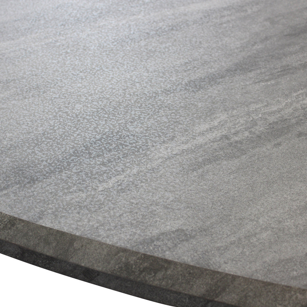 Dettaglio ravvicinato della texture materica in melaminico che simula la pietra naturale sul tavolo Dalbert.