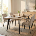 Tavolo da pranzo Dalbert in melaminico marrone chiaro ambientato in una sala da pranzo luminosa con quattro sedie beige.