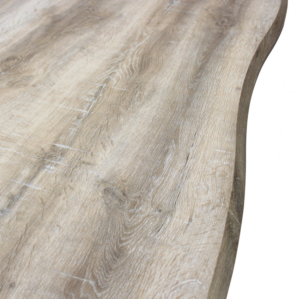 Primo piano della superficie del tavolo Dalbert, con venature e nodi del legno finemente riprodotti sul melaminico.