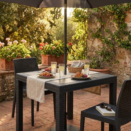 Dettaglio del tavolo da esterno Dallas 80x80 cm apparecchiato per la colazione in un patio rustico.