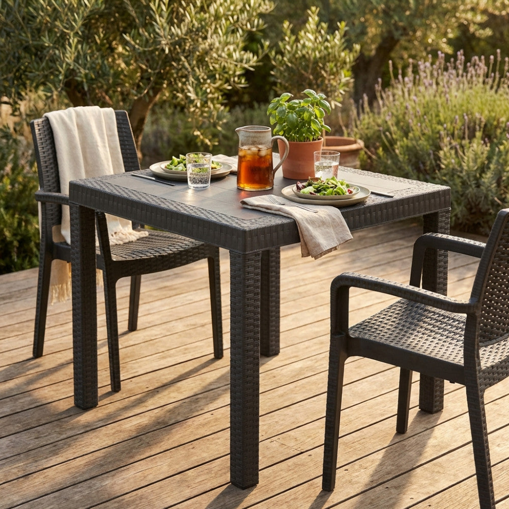 Tavolo da giardino Dallas 80x80 in wicker taupe allestito per un pranzo all'aperto su una terrazza in legno.