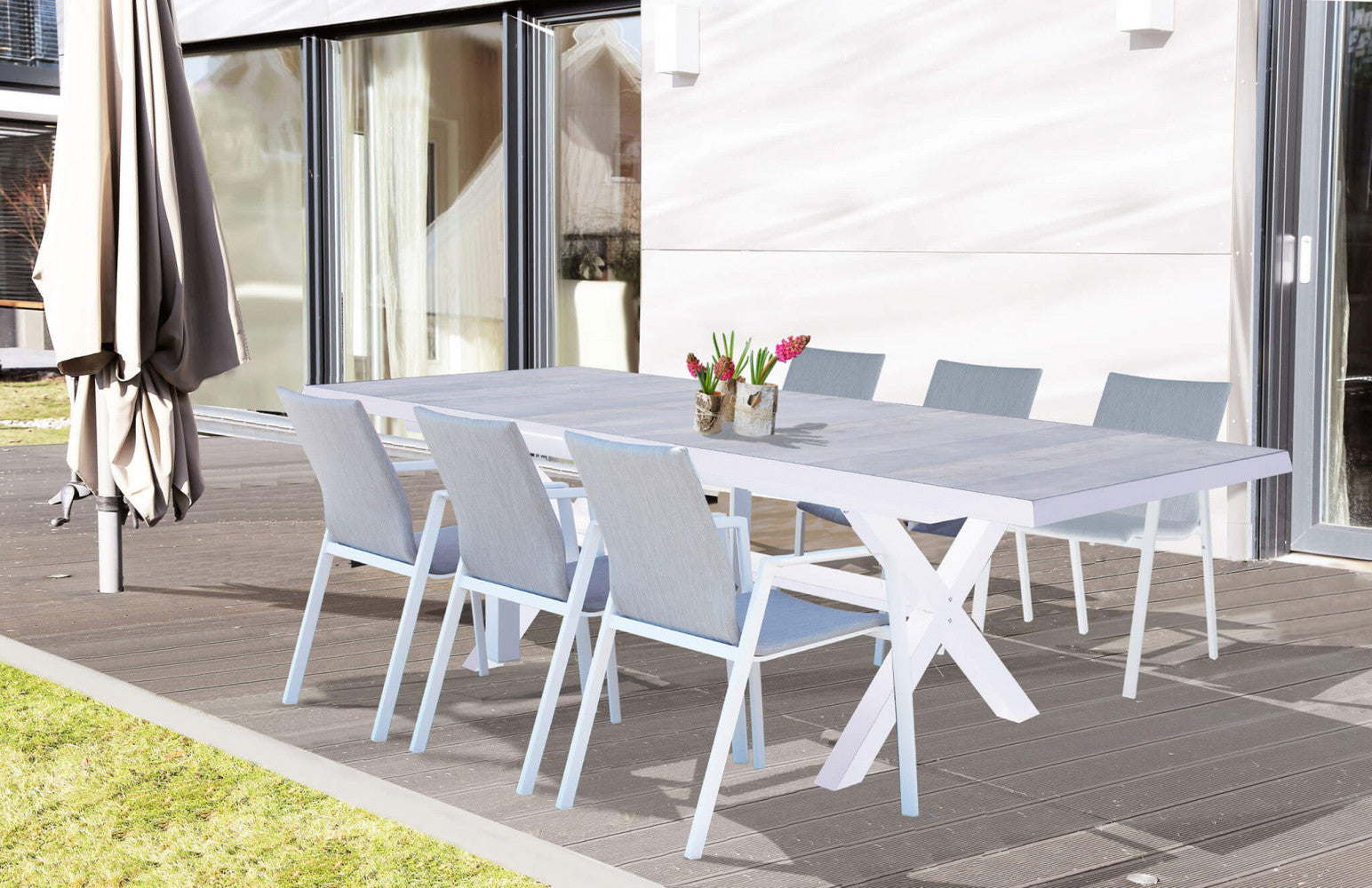 Tavolo da giardino Djerba in alluminio bianco e gres allestito su un patio in legno con sedute coordinate.