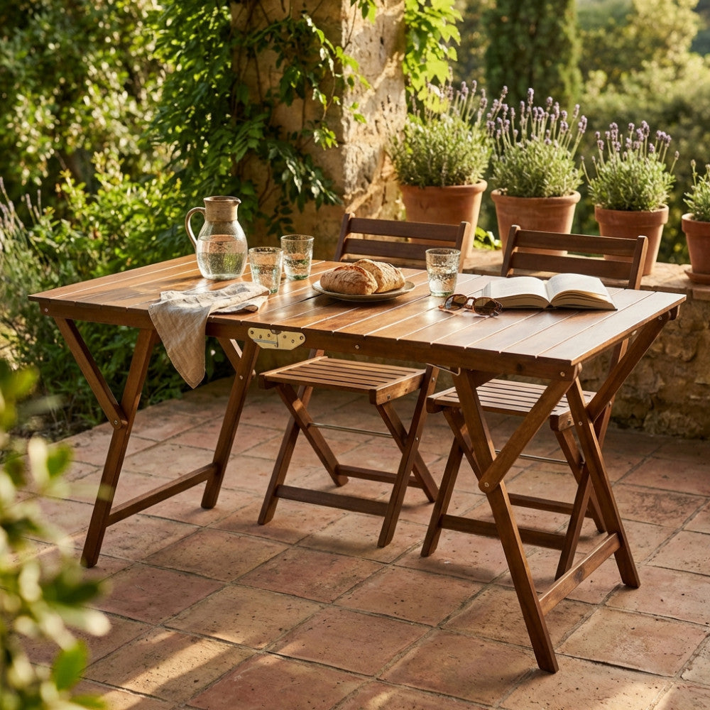 Tavolo da giardino doppio in legno tinta noce allestito su un patio in cotto con sedie pieghevoli e stoviglie in vetro.