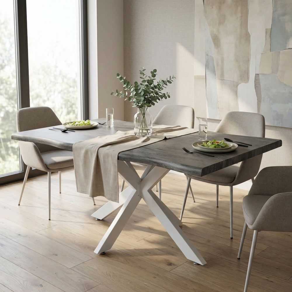 Dettaglio del tavolo da pranzo Floyd illuminato dalla luce naturale, decorato con un runner in lino e sedute grigie di design.