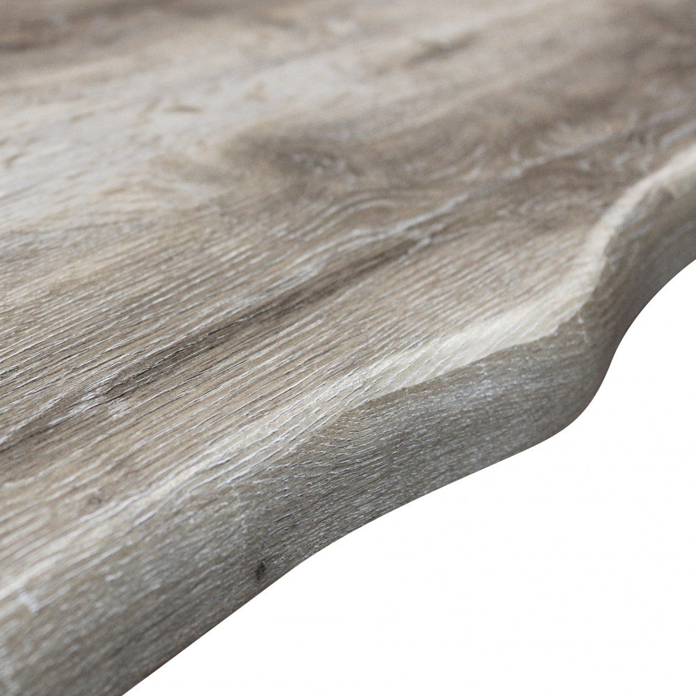 Primo piano del bordo sagomato del tavolo, che mostra le venature realistiche e la texture tattile del melaminico effetto legno nodato.