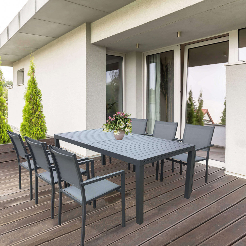 Tavolo Formentera in alluminio antracite ambientato su un patio in legno moderno, abbinato a sedute in tessuto tecnico grigio.
