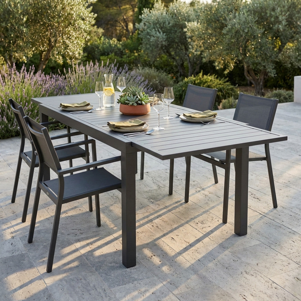 Tavolo da giardino Formentera in alluminio taupe allestito per un pranzo all'aperto su un patio in pietra.