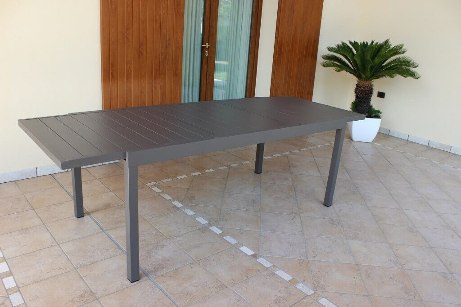 Tavolo Formentera completamente esteso a 240 cm su un patio piastrellato, mostrando la sua massima capienza.