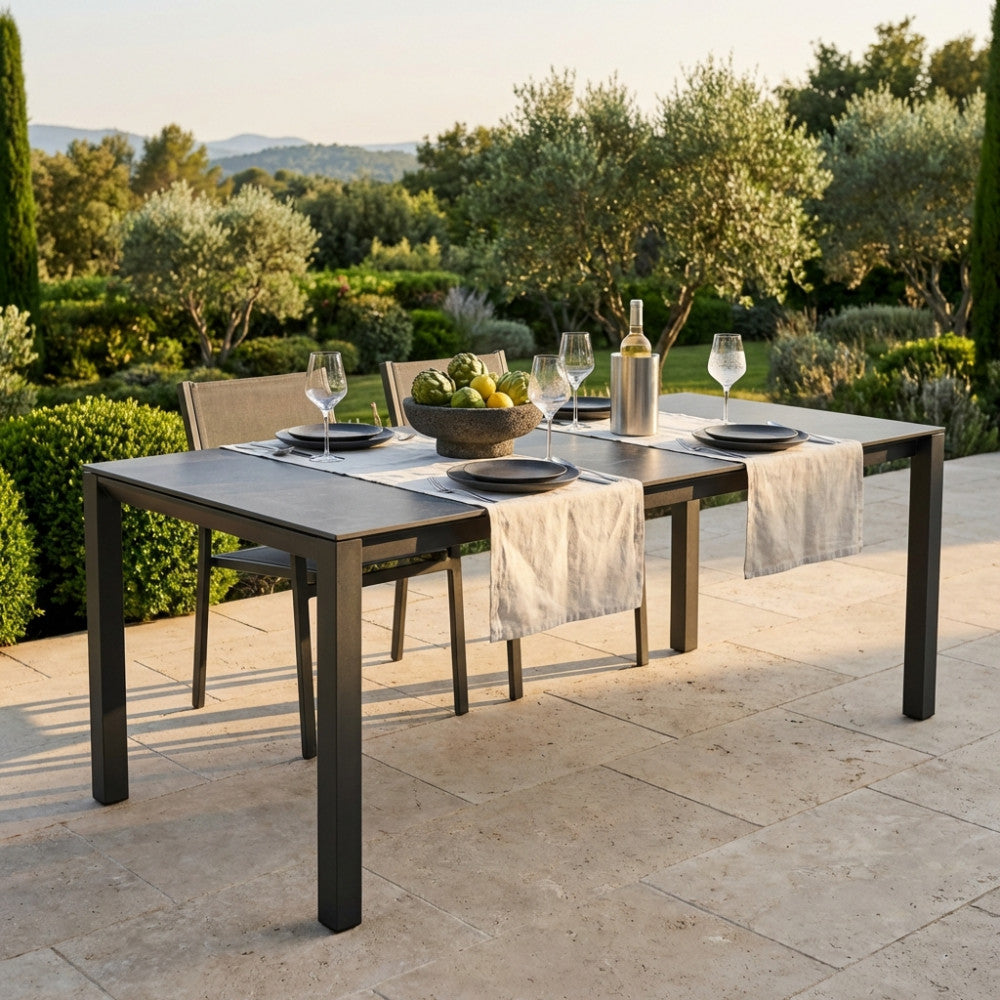 Tavolo da giardino allungabile Freeport in alluminio e pietra sinterizzata antracite allestito per un pranzo all'aperto.