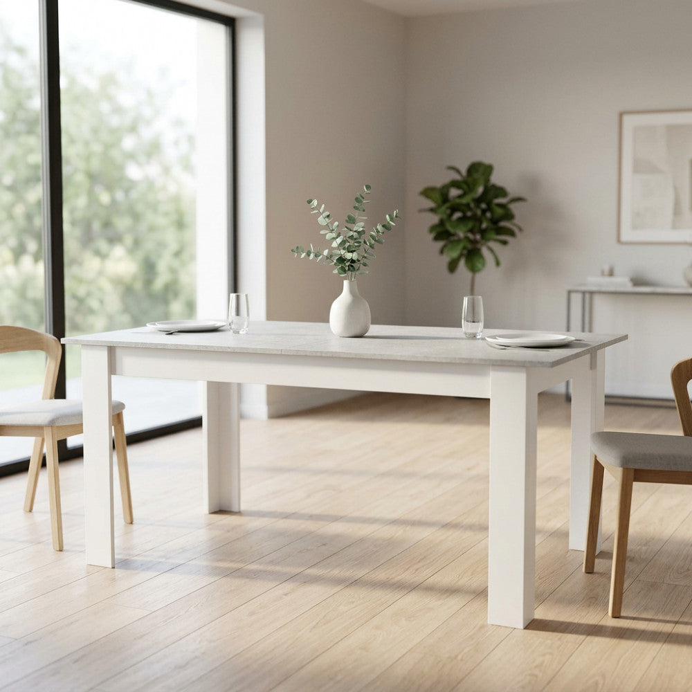 Tavolo da pranzo allungabile Gemma effetto cemento ambientato in una sala luminosa con sedie in legno.
