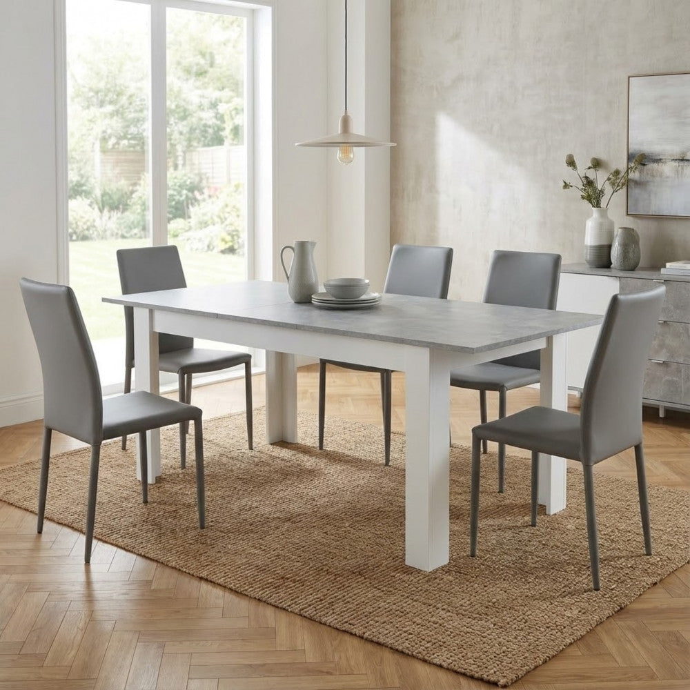 Tavolo da pranzo Gemma esteso in una sala da pranzo contemporanea con sedie grigie in ecopelle.
