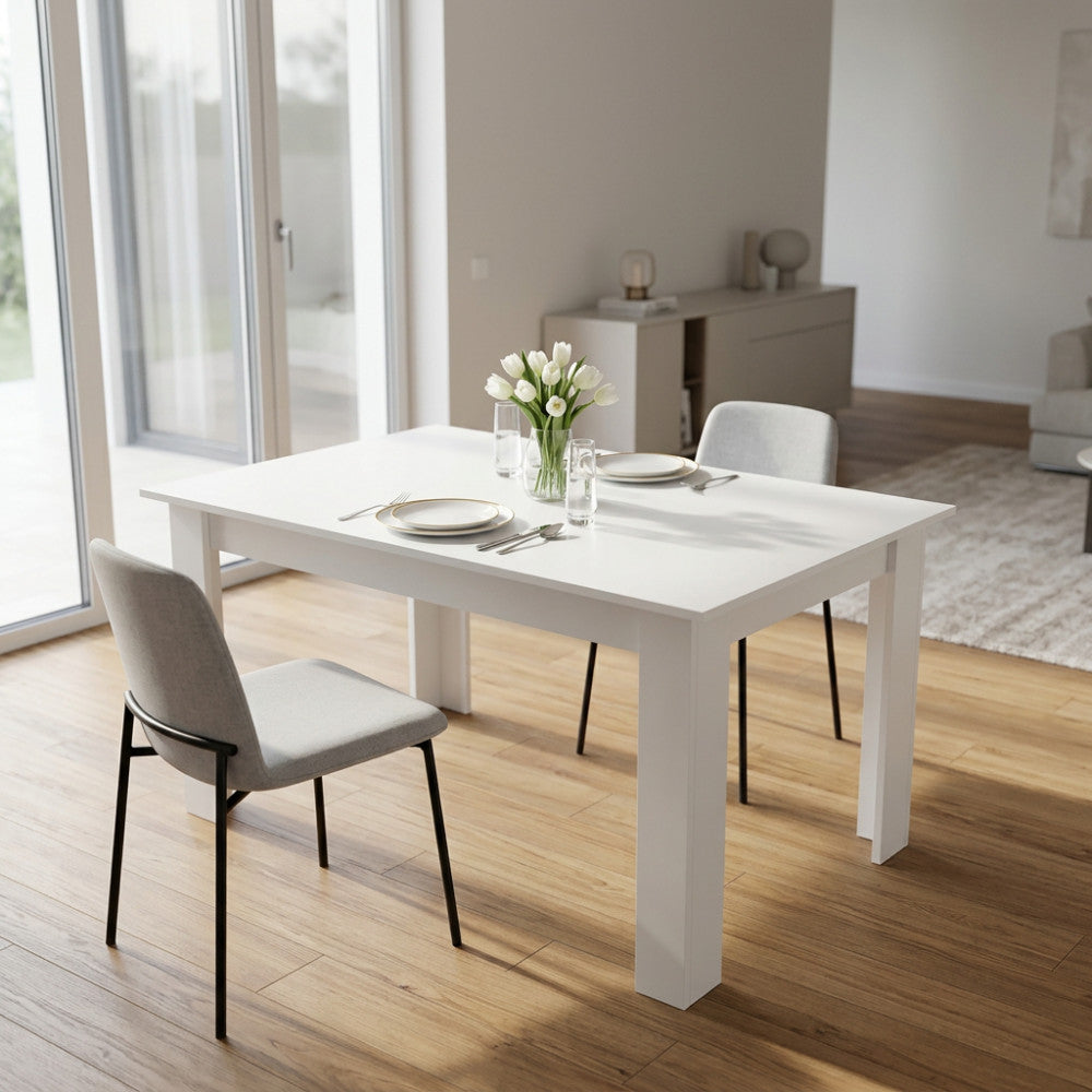 Tavolo da pranzo allungabile Gemma in truciolare bianco, allestito in un soggiorno luminoso con sedute grigie.