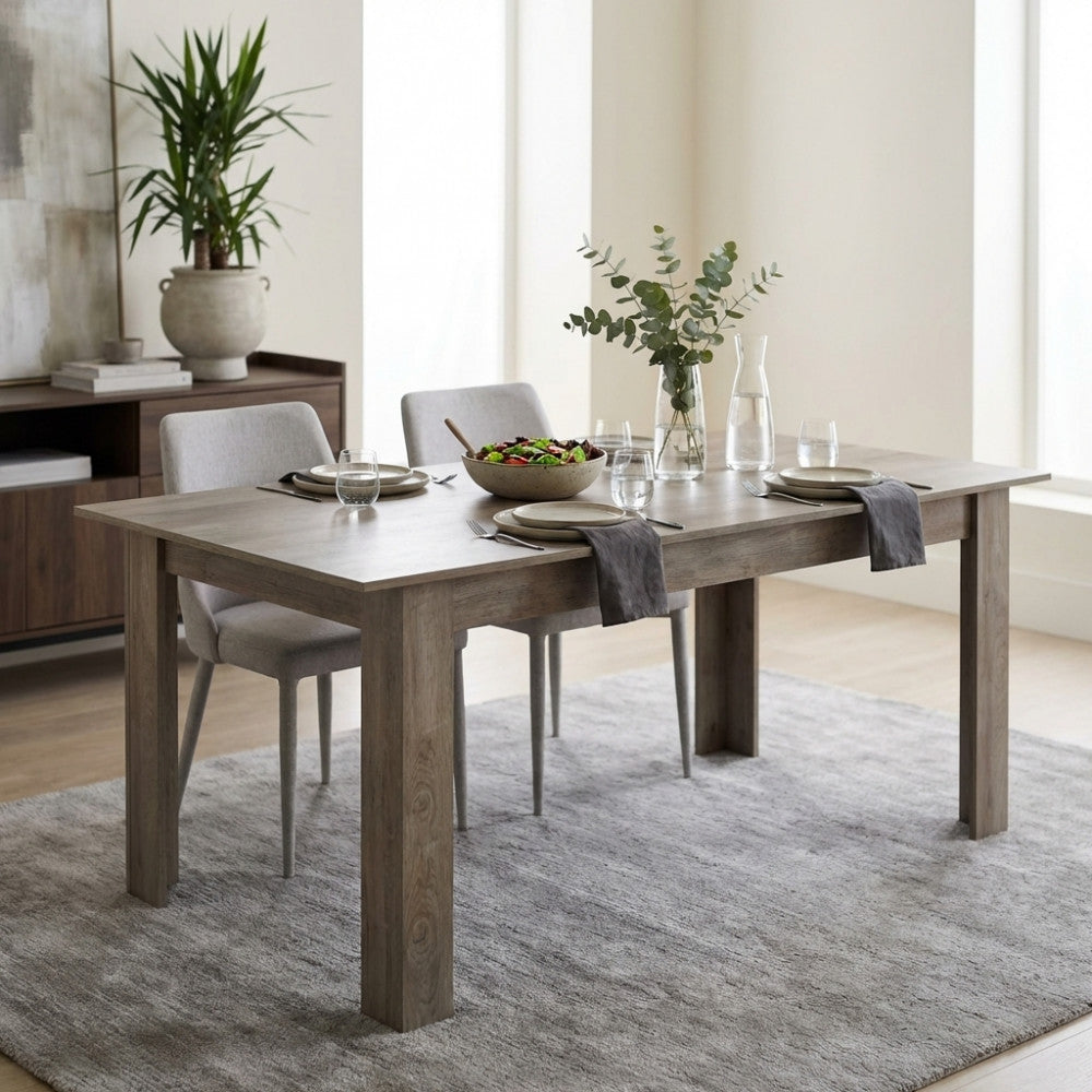 Tavolo da pranzo Gemma in rovere grigio con sedute chiare in un ambiente luminoso e accogliente.