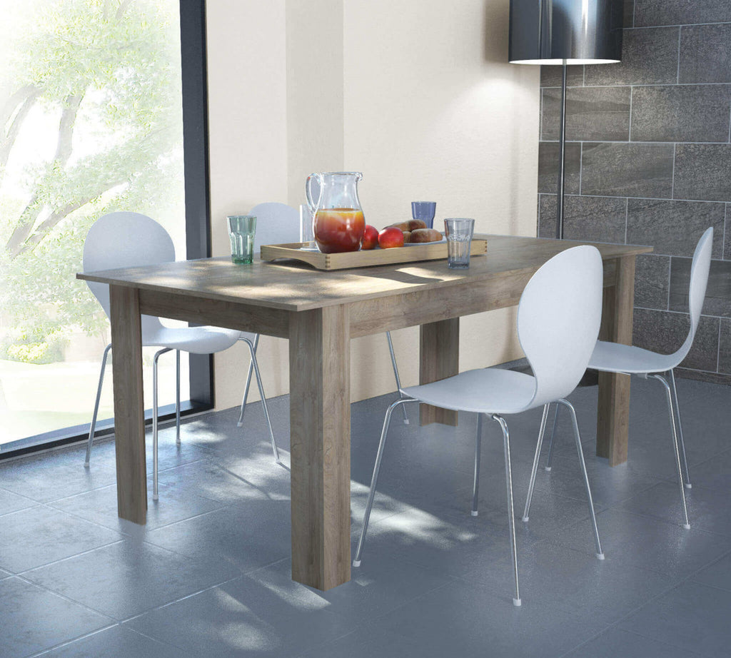 Tavolo Gemma in rovere grigio abbinato a sedie bianche di design, illuminato dalla luce naturale.