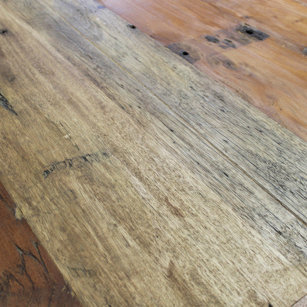 Dettaglio della superficie del tavolo in legno 100% riciclato, con sfumature cromatiche naturali.