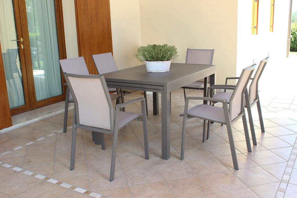 Tavolo da giardino Hawaii chiuso in alluminio taupe, allestito in un patio coperto con sedute in tessuto.