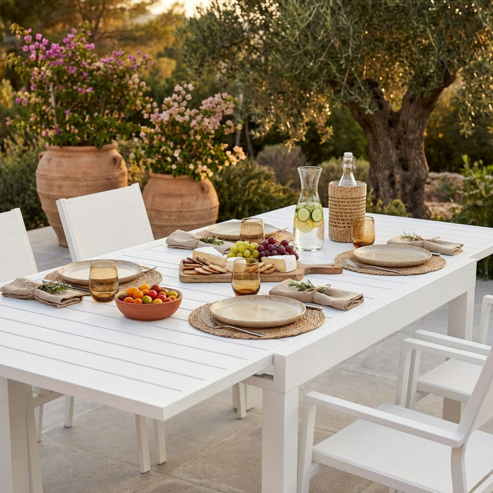 Primo piano della superficie a doghe del tavolo da pranzo Hawaii, decorato con un tagliere gourmet e bevande in un rigoglioso giardino.