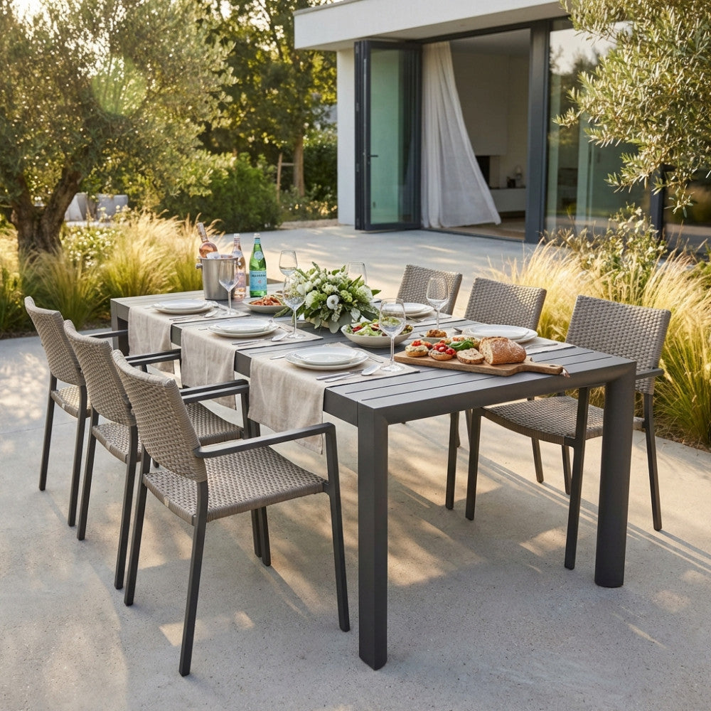 Tavolo da giardino Houston allestito per un pranzo all'aperto con sedie in corda intrecciata e decorazioni floreali.