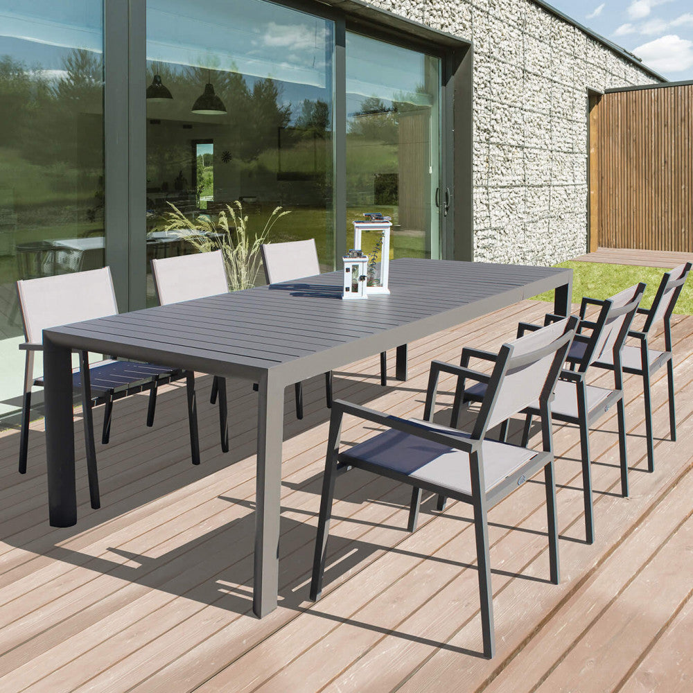 Tavolo da giardino Houston esteso a 180 cm su un patio in legno, circondato da sedie da esterno moderne.